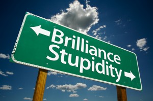 "Brilliance, Stupidity" Road Sign with dramatic clouds and sky.